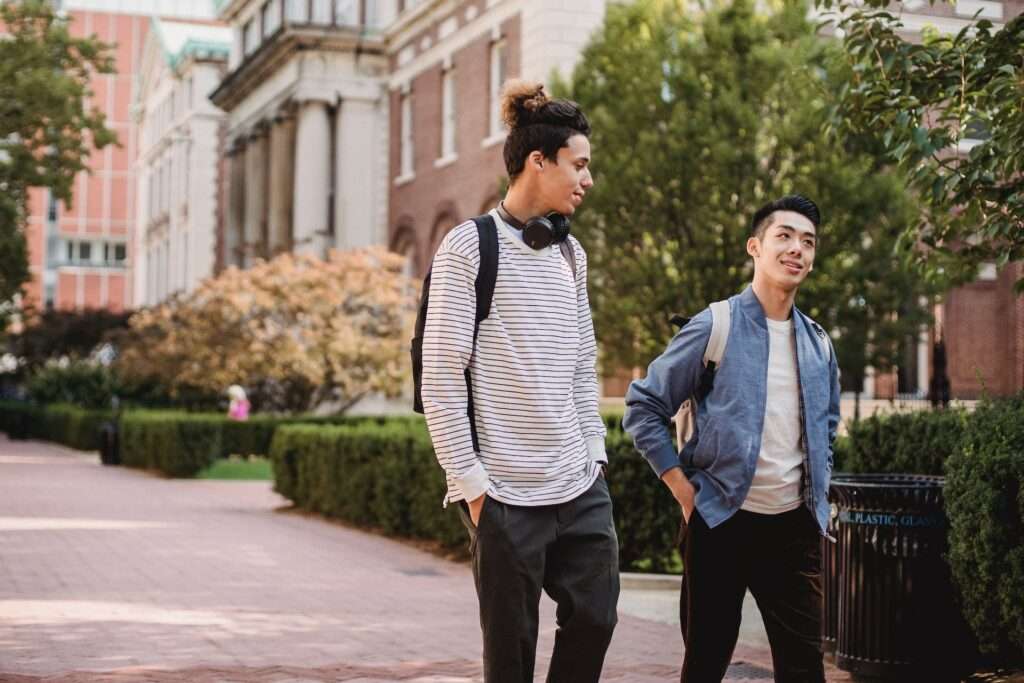 Multiracial male friends talking while strolling in street