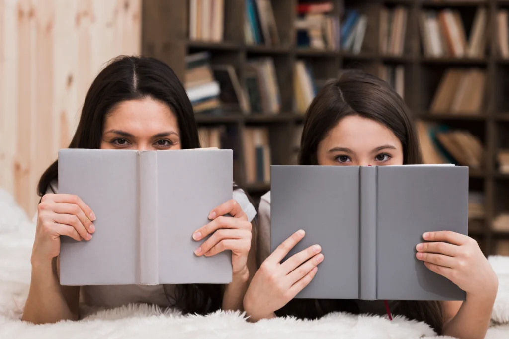 cute young girl woman covering faces with books